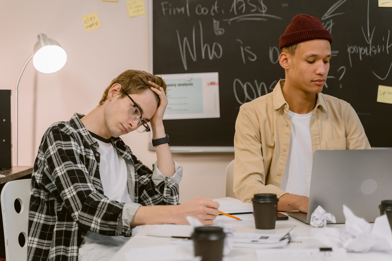 Two young men engaged in creative brainstorming session at a modern office.